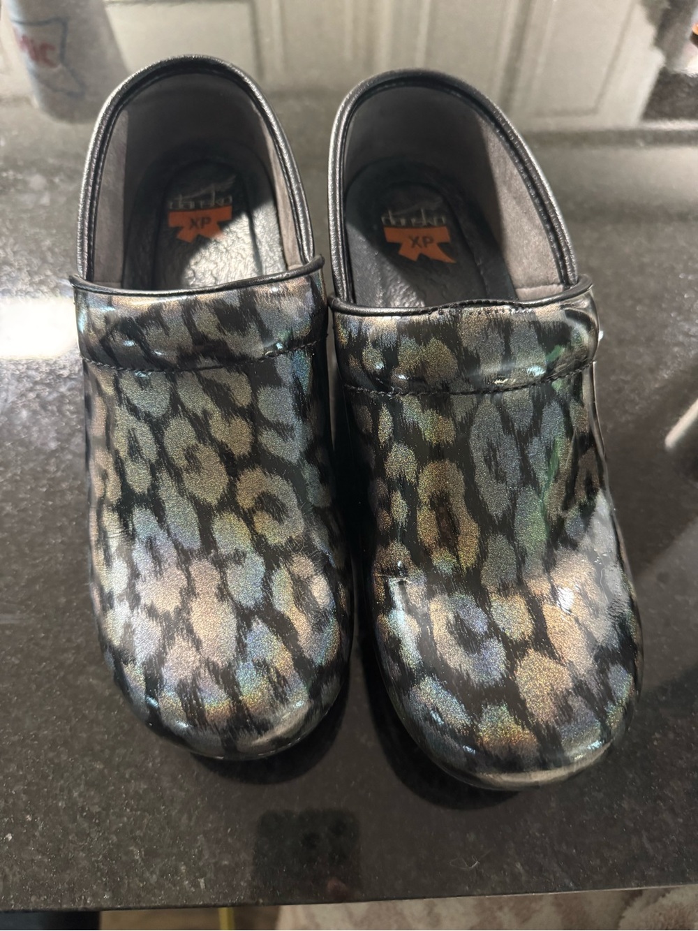 Dansko Iridescent Leopard Print Slip-On Clogs in Black